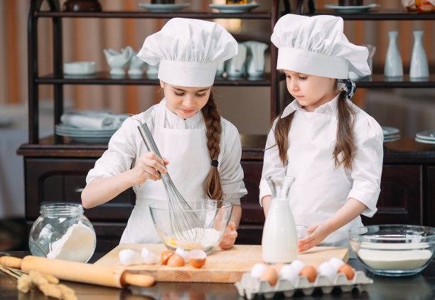 有趣的女孩，孩子们正在厨房里准备生面团。图片下载