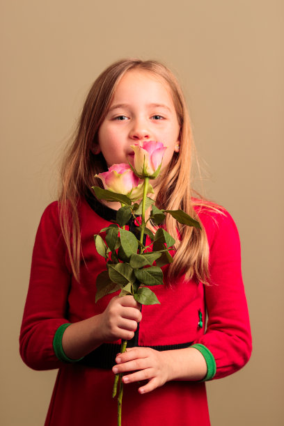 漂亮的年轻女孩闻着花香图片下载