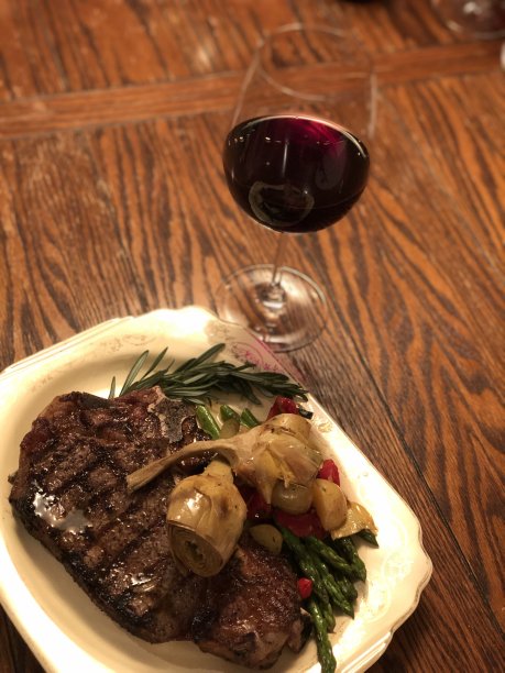 一个浪漫的夜晚火焰烤骨柚木与罗马洋蓟心烤芦笋与一杯解百纳图片下载