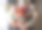 非常漂亮的年轻女子捧着一大束美丽的玫瑰、康乃馨和桉树花，在灰色的墙壁背景上从白色到鲜红的渐变颜色图片下载