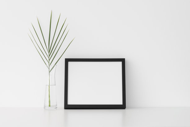 黑色框架模型与棕榈叶在玻璃花瓶。横向。图片下载