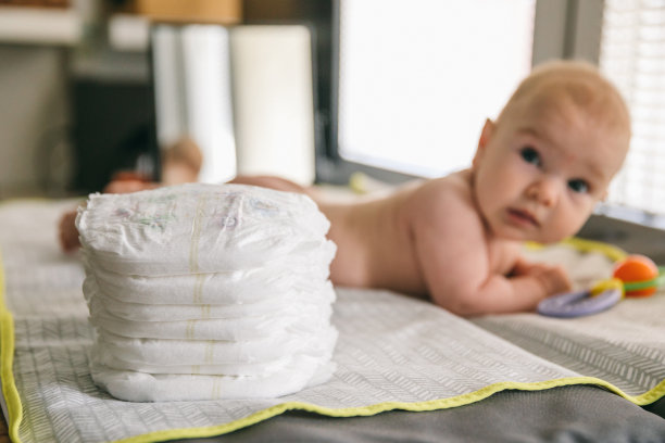 两个月大的婴儿和一堆尿布。如何选择婴儿尿布图片下载
