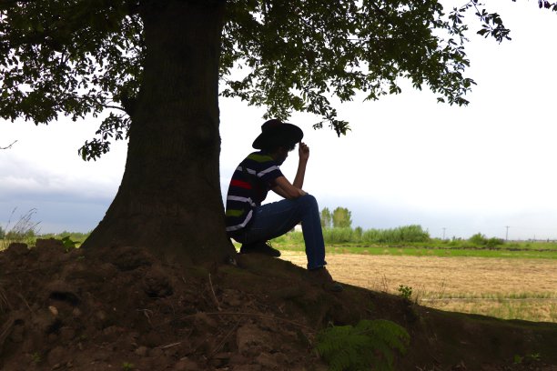 在田野边看植物的年轻男子轮廓图片下载
