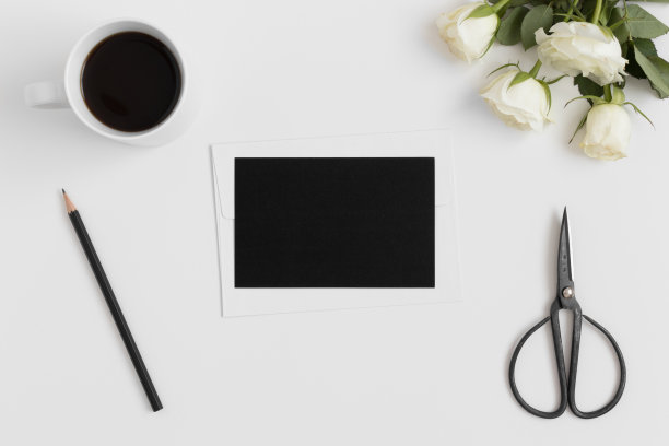 顶视图的黑卡模型与一束玫瑰和工作配件在白色的桌子上。图片下载