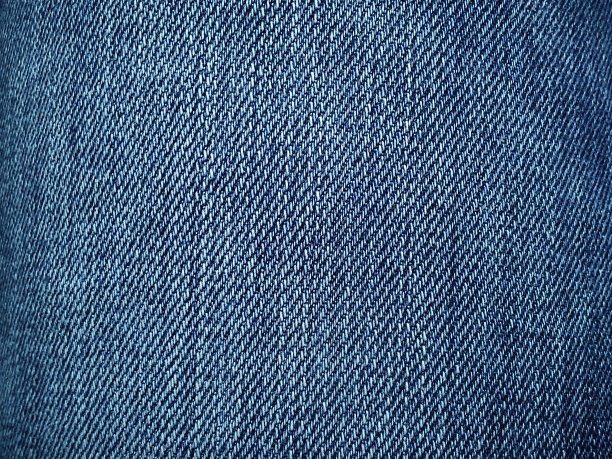 蓝色的牛仔。棉质地粗料。一块天然靛蓝破布的碎片。垂直的皱纹，深色和浅色的线，单独的缝线是显而易见的。图片下载