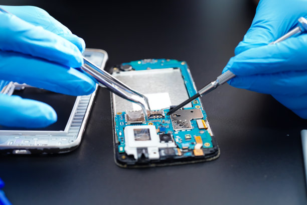 技师通过烙铁修理手机内部。集成电路。数据、硬件、技术的概念。图片下载