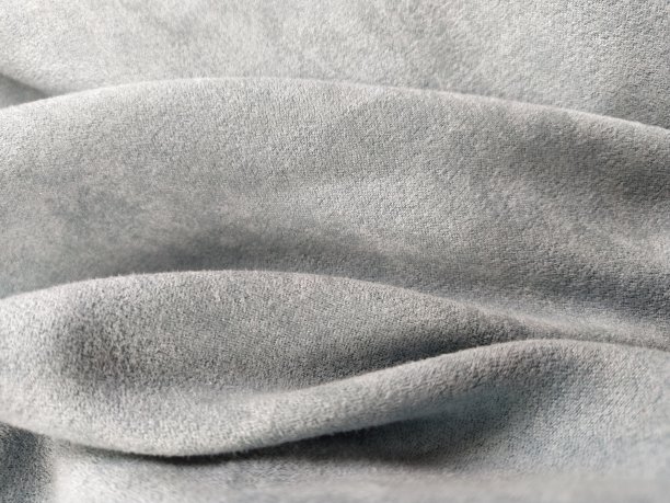 面料透明窗帘面料。美丽的灰蓝色的颜色。有绒毛的柔软天鹅绒。窗帘料子在水平面上随意折叠起皱。面料样品。室内设计方案图片下载