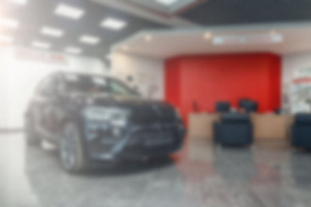 多品牌汽车经销商。模糊的背景，汽车和展厅在工作场所模糊。模糊的经销商店，与汽车和柔和的闪电。新的红色的汽车图片下载