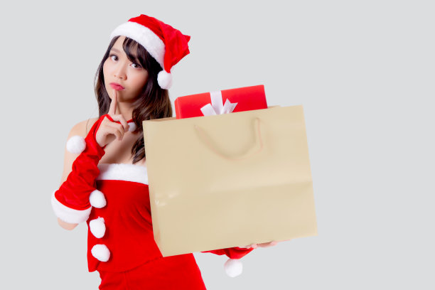 美丽的肖像年轻的亚洲女人快乐和兴奋拿着纸袋与礼物盒在圣诞假期孤立的白色背景，女孩购物和惊喜在圣诞和新年。图片下载