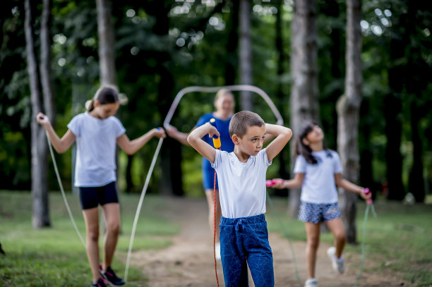 穿着白色t恤的学生在公园里跳绳图片下载