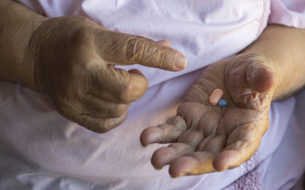 老妇人把手里的药丸拿出来。医疗和药品。图片下载