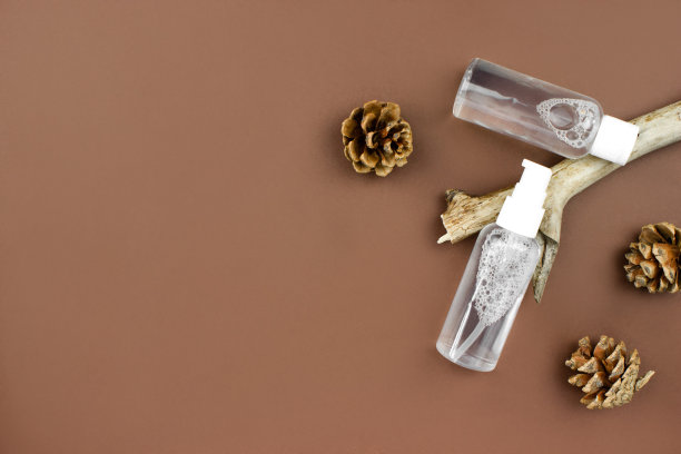 装着洗液的美瓶、补液放在木树枝上，圆锥体平躺在棕色背景上俯视。美容护肤。有机、生物、天然的化妆品理念。美容和水疗概念。库存图片图片下载