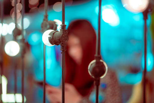 模糊图片上的女人在明亮的散景灯上的椅子装饰在户外节日市场在葱翠的熔岩色调图片下载