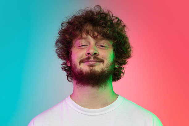 高加索年轻人的肖像在渐变工作室背景霓虹灯图片下载