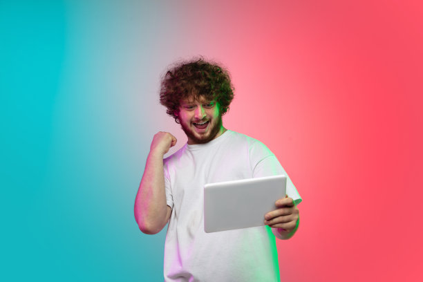 高加索年轻人的肖像在渐变工作室背景霓虹灯图片下载