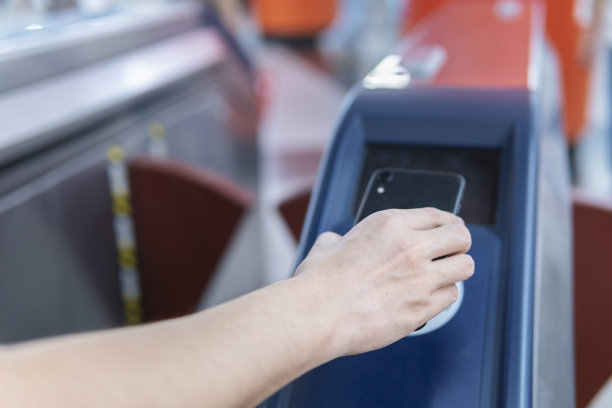 一名亚洲男子在地铁站用移动支付的手机结账图片下载