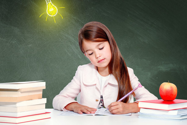 年轻可爱的女孩在黑板前，头上顶着一个灯泡图片下载