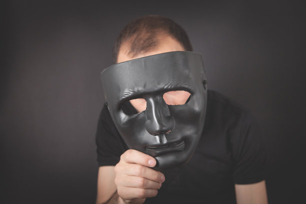 拿着黑色面具的男人。假的,匿名图片下载