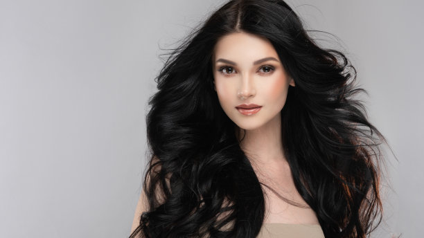 黑头发的女人，有卷卷的，有光泽的和卷曲的发型。卷曲的头发。图片下载