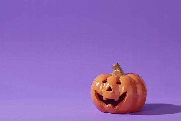 紫罗兰色背景上的南瓜，万圣节背景。图片下载