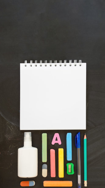 俯视图上的彩色文具。回到学校平铺的概念。水平16:9黑板背景与复制空间的记事本。图片下载
