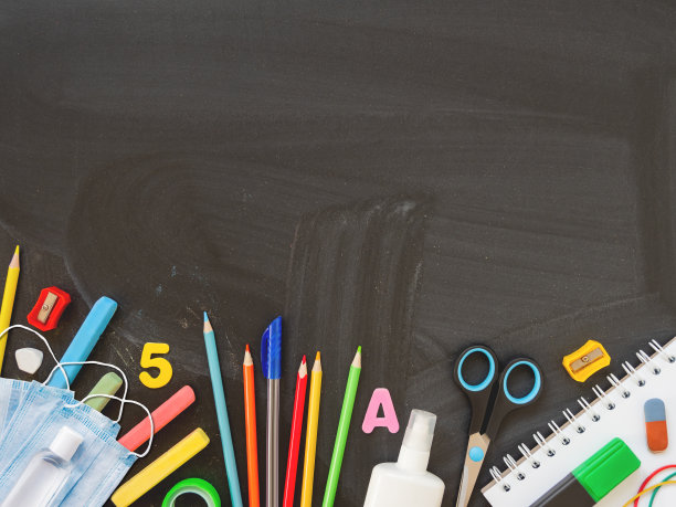 俯视图上的彩色文具，防护医疗口罩和洗手液。回到学校平铺的概念。水平黑板背景与复制空间。学校购物。新常态图片下载