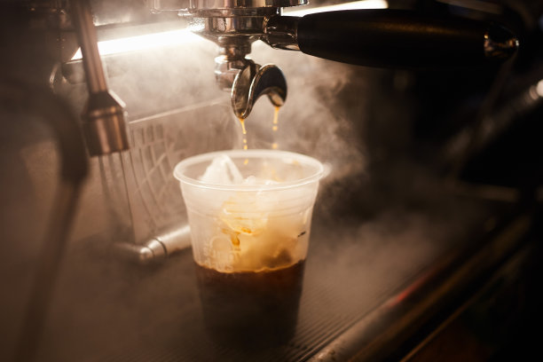 热浓缩咖啡倒入加冰的杯子图片下载