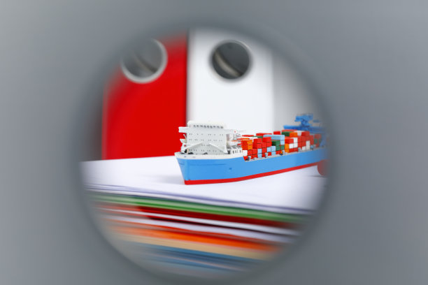 集装箱船模型在一堆彩色的办公纸上图片下载