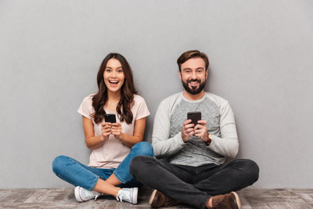 一对兴奋的年轻夫妇拿着手机图片下载