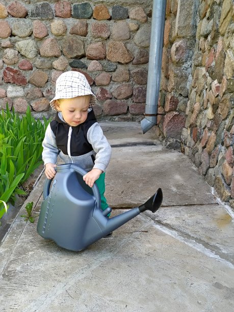 一个小男孩微笑着站在绿色的草坪上。快乐宝贝。儿童保护的一天。无忧无虑的童年。图片下载