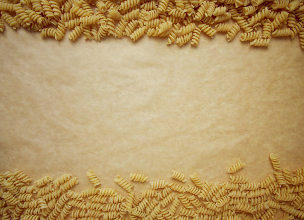 螺旋面食在牛皮纸背景与复制空间。俯视图图片下载