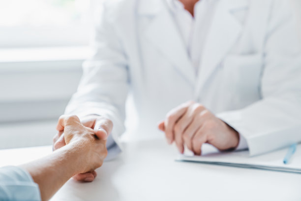 医生和病人握手的特写。图片下载