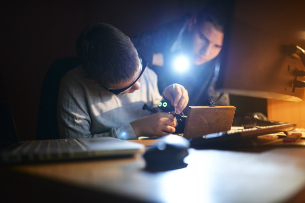 两兄弟在深夜创造了一个机器人。对电子产品的热情。图片下载