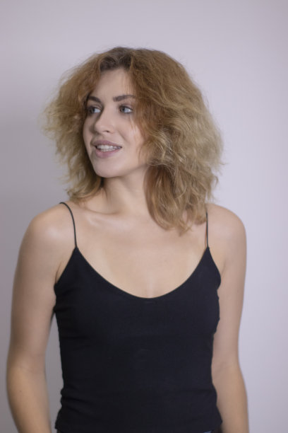 一个美丽的卷毛金发红发穿着黑色汗衫的情感肖像图片下载