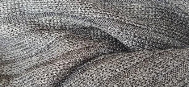 针织产品。黑白照片。一件针织毛衣的环和纹理特写。编织毛线和腈纶线。工业休闲服生产。单色。软焦点横幅图片下载