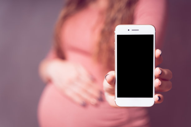 孕妇与智能手机，显示手机空白屏幕。智能手机模型，移动应用的复制空间。怀孕、技术、准备和期望的概念图片下载