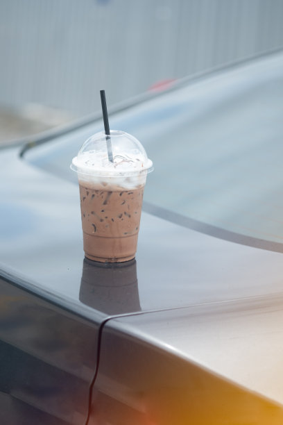 老人忘记了在汽车前车顶用塑料玻璃盛着的冰摩卡咖啡。图片下载