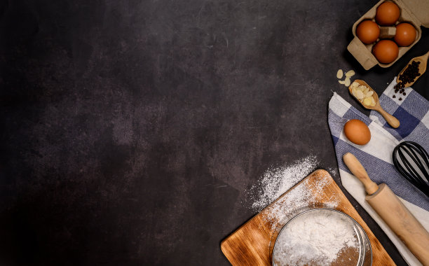 用面粉自制烘焙原料，在深色背景下制作蛋糕。俯视图和平放照片与文本复制空间。图片下载