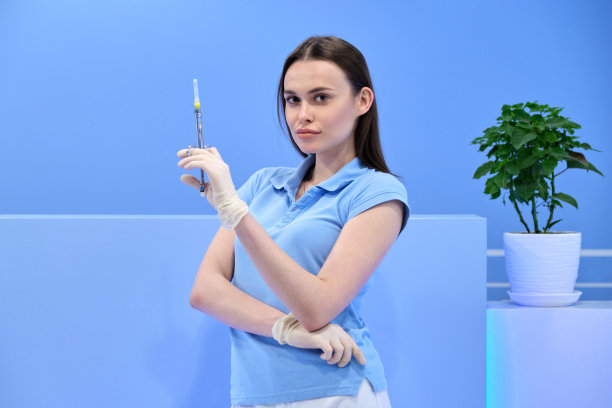 漂亮的年轻女医生手里拿着注射器，女护士看着镜头图片下载