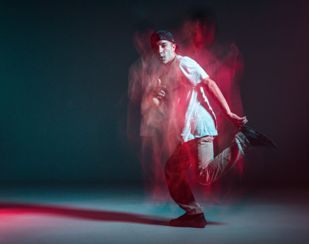 时髦的年轻人在霓虹灯下跳嘻哈舞。舞蹈学校的海报。长时间曝光拍摄图片下载