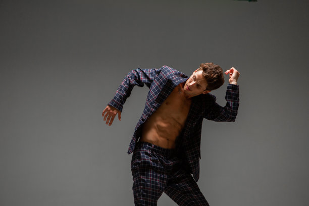 英俊的年轻人舞者在西装跳舞表现力的舞蹈。舞蹈学校的海报图片下载