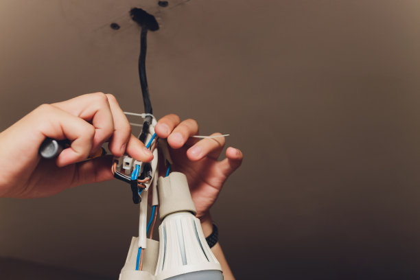 一个电工。修复工作。吊灯挂在天花板上。图片下载