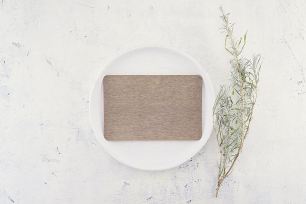 空棕色空白商务或婚礼卡片模型上的白色复古盘子，网页横幅设计，贺卡在灰色桌子背景在普罗旺斯风格与植物的枝条。前视图。图片下载