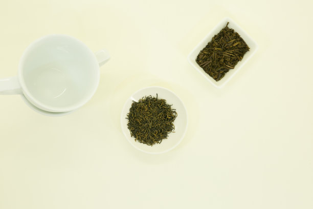 东方茶。中国茶金眉美人和日本绿茶炒茶。孤立于白底白碗中。图片下载