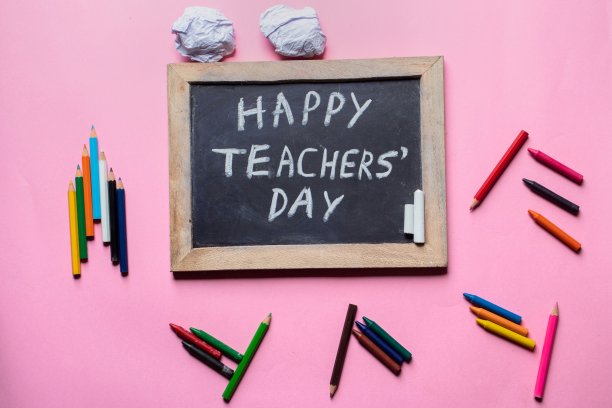 教师节快乐创意照片与黑板和铅笔孤立在粉红色的背景，完美的壁纸图片下载