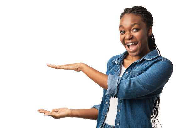 快乐的黑色女孩在牙套拿着看不见的东西，工作室拍摄图片下载