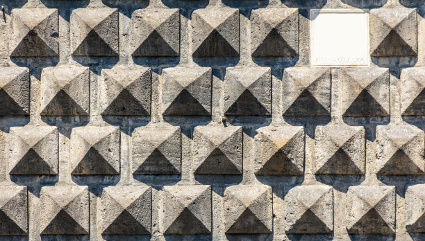 在阳光的照射下，一面墙的纹理用石头砌成，特写用白色大理石题字。图片下载