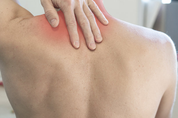 男人握住他的手，因为他的肩膀和脖子都发红了。男人脖子疼，肩膀疼图片下载