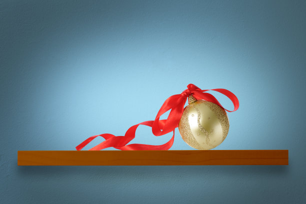 靠在蓝墙的木架子上的圣诞球图片下载