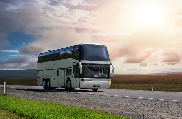 旅游巴士载着乘客沿着风景而行图片下载